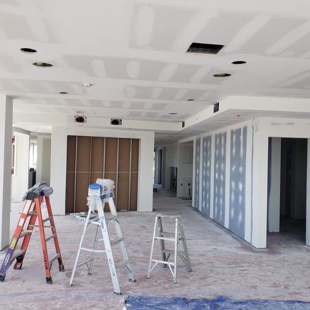 Commercial painters refreshing office hallway walls while protecting floors and door frames